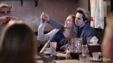快乐的夫妇在咖啡馆<strong>玩</strong>，用智能<strong>手机</strong>自拍美丽的青少年夫妇用<strong>手机</strong>自拍